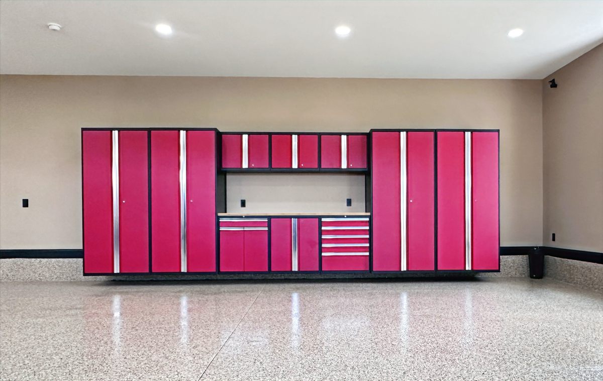 A red NewAge garage cabinet system with a work surface, installed over a polished flake floor.