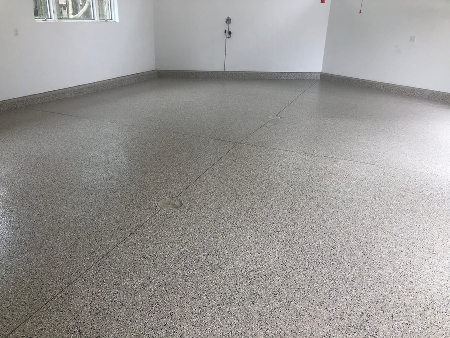 Attached garage with a light gray flake coating and clean coved edges.