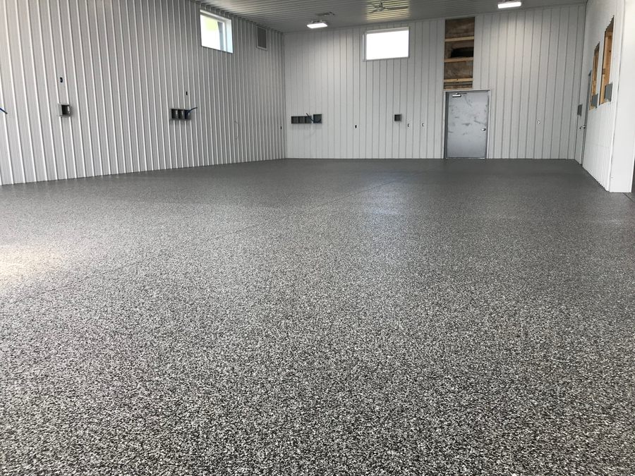 Pole barn interior with white steel walls and a wall to wall flake floor.